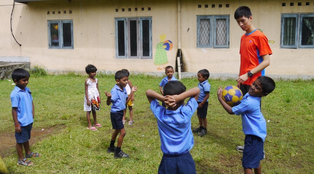 A Projects Abroad volunteer works as a sports coach with young students in schools in Sri Lanka A volunteer coaching sports in schools in Sri Lanka plays a ball game with students